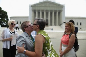 WASHINGTON, DC - JULY 24: Libby Enloe (2nd L) and Amanda Adams, both of Winston-Salem, North Carolina, embrace and kiss after being married outside the U.S. Supreme Court building on Capitol Hill July 24, 2013 in Washington, DC. Enloe's mother, Mary Ann Enloe (L) and Adams' sister, Meredith Boggs (R), were witnesses to the ceremony. A couple for more than 21 years, Enloe and Adams decided to get married outside the court after the justices struck down the Defense of Marriage Act last month. The location is symbolic, Enloe said. "This makes it official which is what we were waiting for," she said. (Photo by Chip Somodevilla/Getty Images)